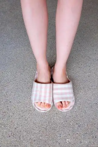 格子拖鞋, 关闭的女人粉红色的家庭拖鞋脚和腿背景照片-正版商用图片0