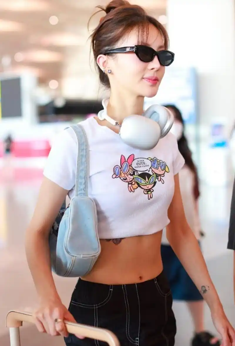 金晨戴耳机墨镜现身机场 穿露脐装大秀马甲线.