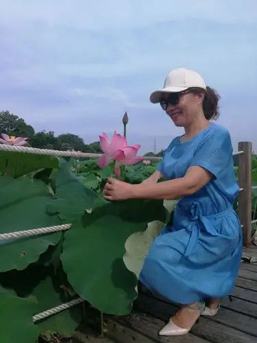 美女双手捧着荷花,笑得多甜蜜好似中了大奖一样.