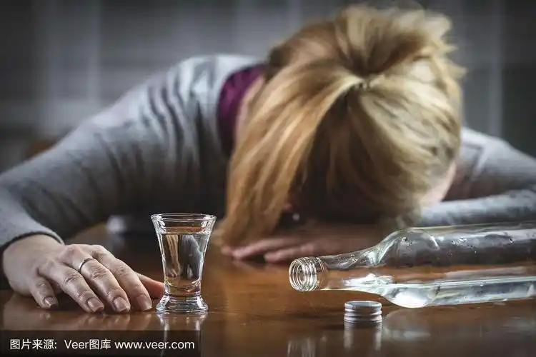 喝了伏特加后睡在桌子上的醉酒女人
