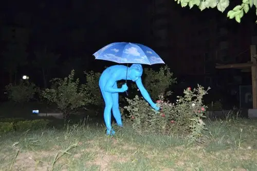 行为艺术家全身图蓝抱充气娃娃裸奔