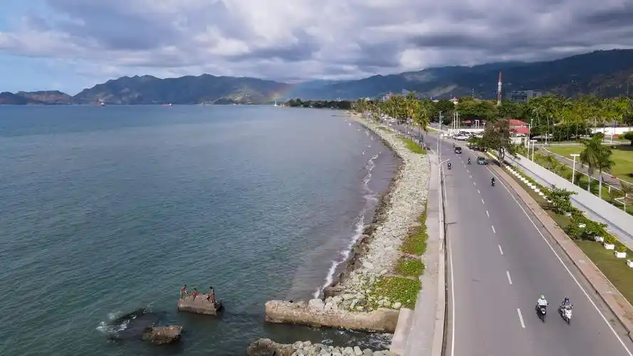 6月6日,在东帝汶首都帝力,一道彩虹出现在海边(无人机照片).