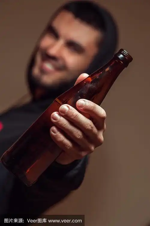 年轻的男人手里拿着啤酒瓶