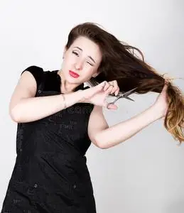 女性理发师试图用剪刀剪你自己的头发照片