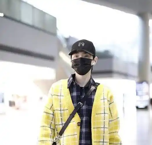 汪苏泷现身机场,只见他上身穿一件亮黄色格纹毛衫.