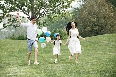 自然美放松公园一家三口在草地上玩耍图片素材