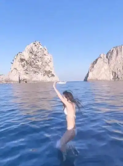 网站上晒出了自己的旅游vlog,其中还包括了她穿着比基尼跳海的泳装照