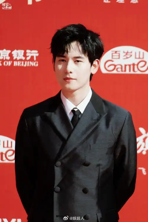 胡先煦穿着黑西服拿着一枝红玫瑰走地毯,还对粉丝比心这哪里是在走