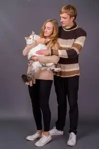 抱着波斯猫的年轻夫妇的肖像照片