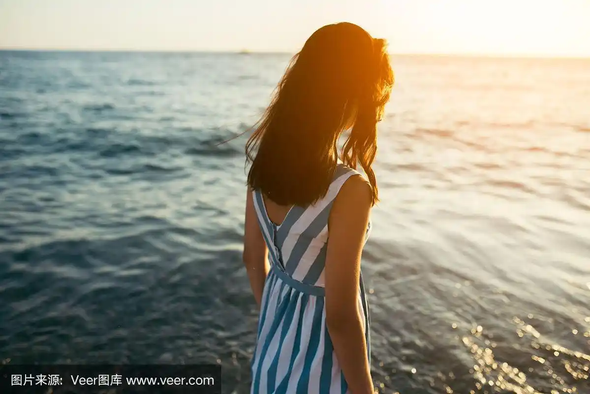 在海洋上行走的女性望着太阳.孤独和悲伤的概念.