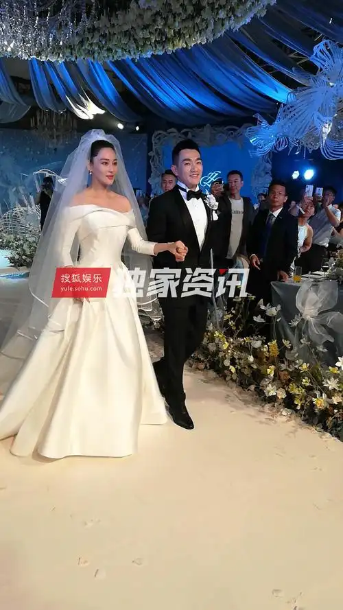 现场照片曝光,照片中新郎何捷手牵着新娘张馨予步入礼堂,幸福的笑容在