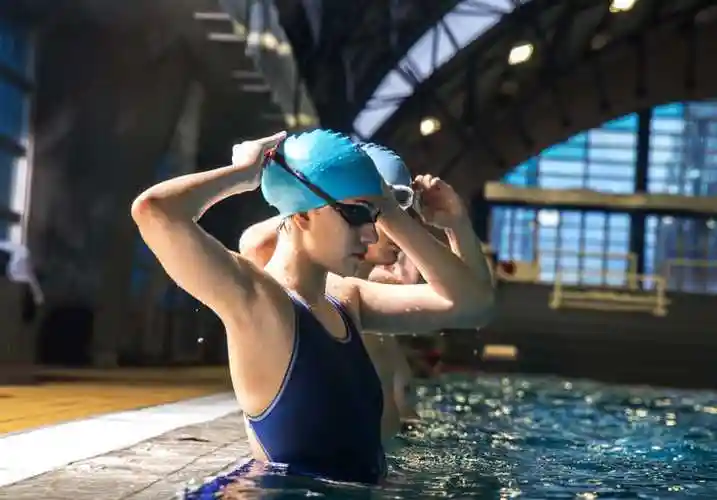 正在清澈干净的游泳池游泳的人