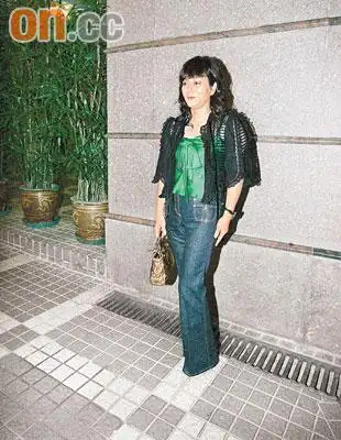 身穿绢质绿色上衣衬黑外套的毛玉萍,挽着手袋到场