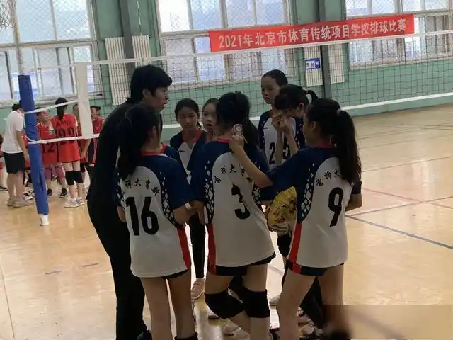 阳光灿烂,赵玉峰站在首都师范大学附属回龙观育新学校的操场边