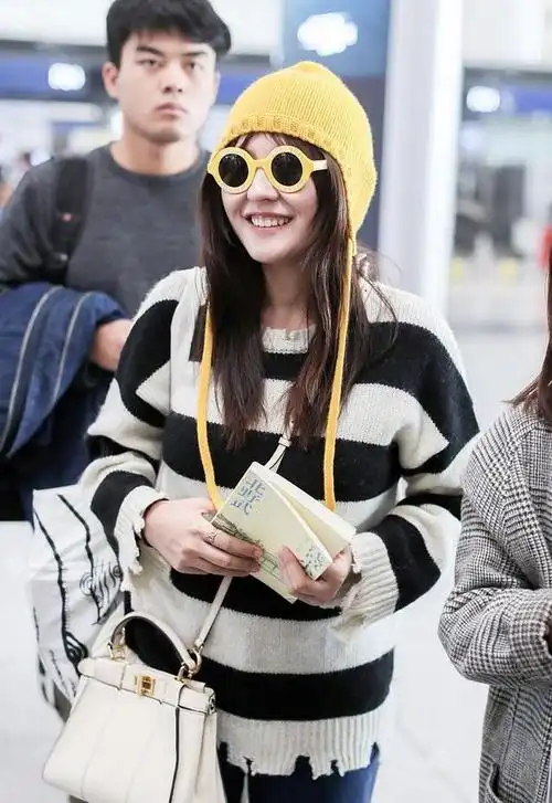 33岁热依扎现身机场穿基础款条纹针织衫搭配牛仔裤