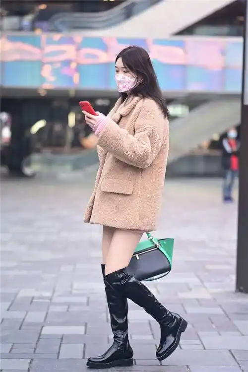 也选择好看的服装,这位美女选择黑色过膝长靴,粗跟款式,也搭配出简约