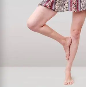 一条腿用一只脚压在膝盖上,单腿站立.照片