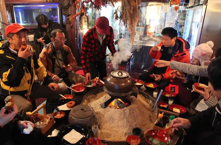 2011年1月16日,游客在日本金山町一家传统豆腐坊里围炉而坐,享用乡村