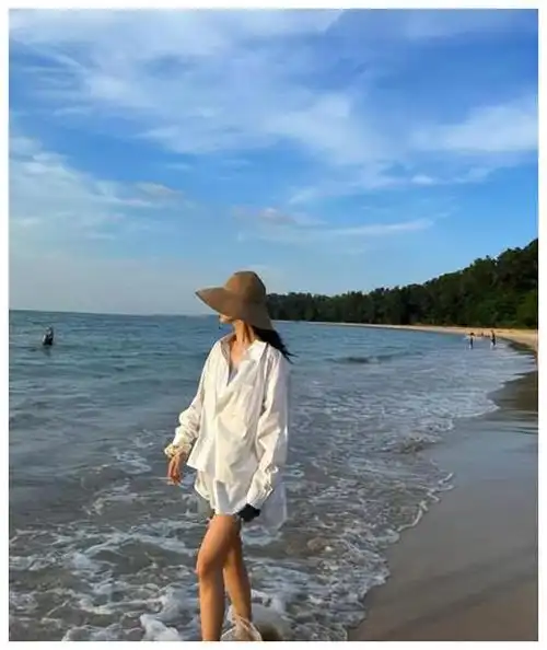 杨紫穿着宽大的白衬衫,里面搭配的应该是泳装,展示了她火辣纤瘦的曲线