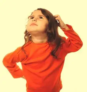 挠头发肖像布鲁内特的孩子橙色毛衣挠他头 thi照片