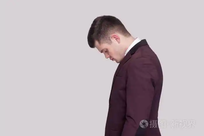 穿着紫罗兰色西装和白衬衫的悲伤英俊的年轻人站在一