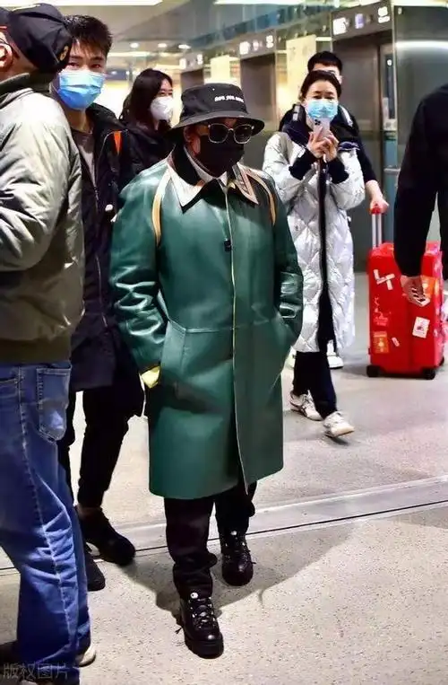 49岁韩红久违亮相机场穿墨绿色大衣包裹严实衣品明显提高太多