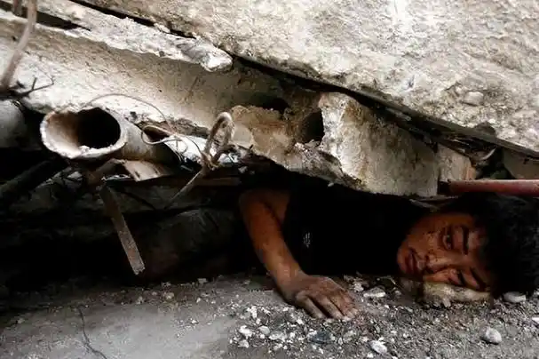 这是08年汶川地震中的真实现场,被压在废墟下的男子名叫陈坚,被水泥板