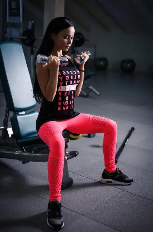 美丽的年轻性感的女孩在健身房锻炼