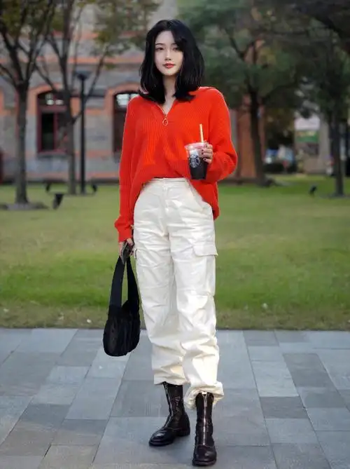 一件橘红色v领针织衫搭配白色工装阔腿裤,显得妩媚又帅气,将衣服的
