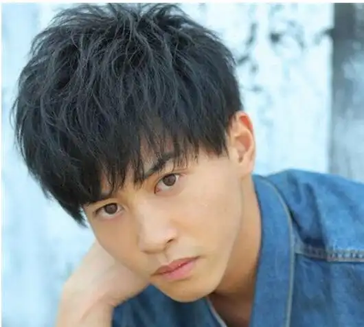 头发是稍长的,这样的男生发型是小卷发式的,再把头发修剪成微碎发式的