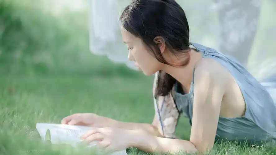 草地上看书的美女高清壁纸图片