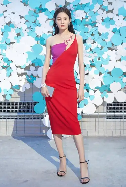 王媛可身穿一件红色的连衣长裙,脚穿一双黑色的高跟凉鞋,手里拿着一个