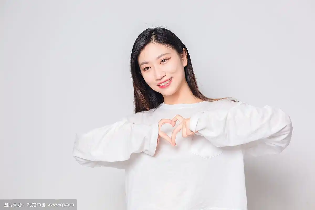 对着镜头用手比心的亚洲美女