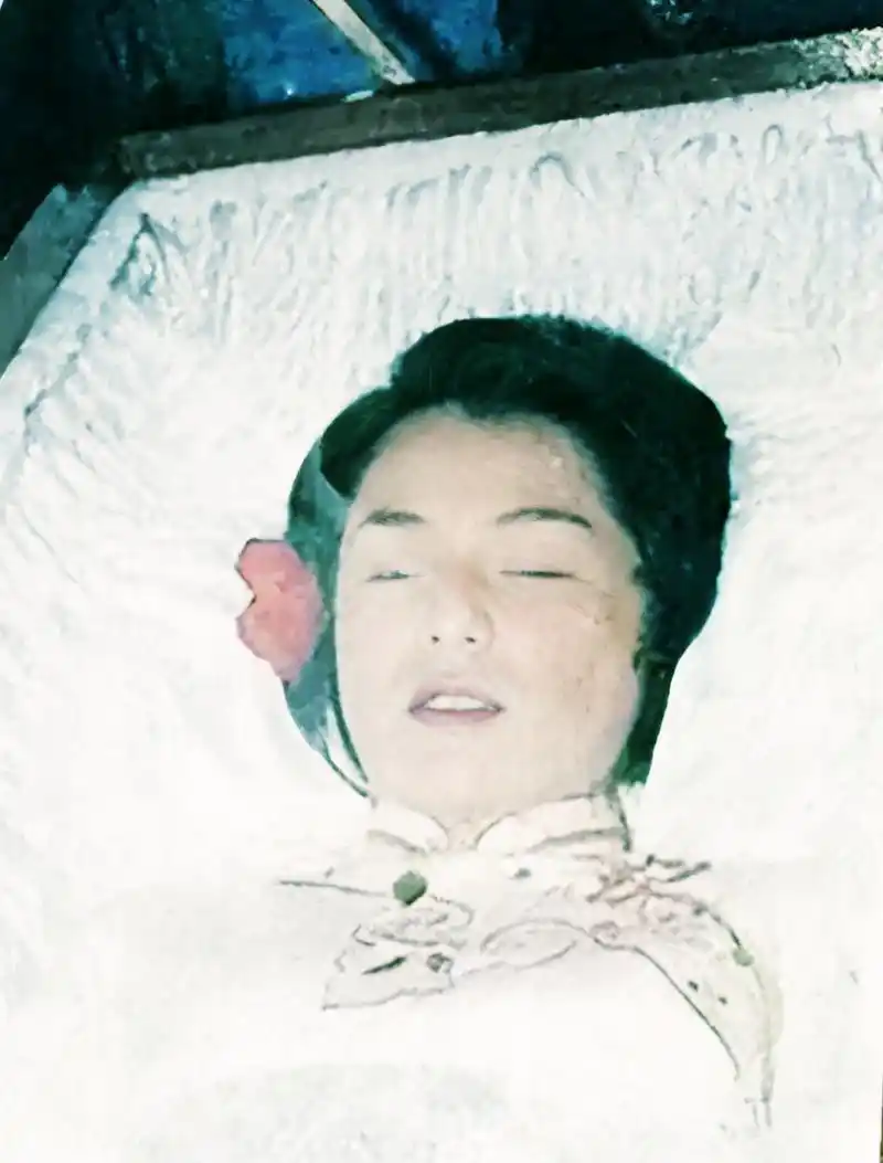 她平静地躺在那里,穿着白色的刺绣服装,汤镇业轻轻