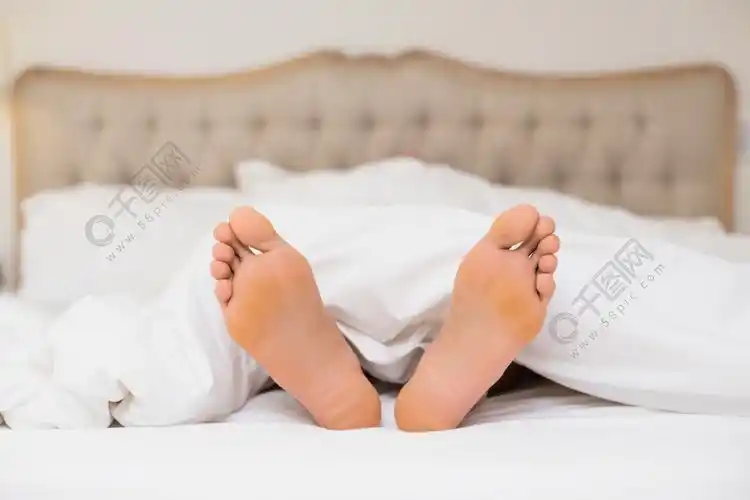 在家里的床上赤裸的双脚