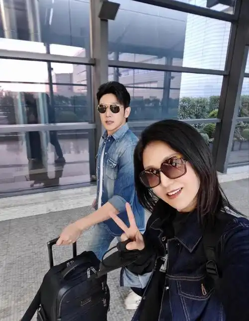 鲍蕾里面穿黑色t恤外面搭配深蓝色牛仔外套下身穿米色裤子