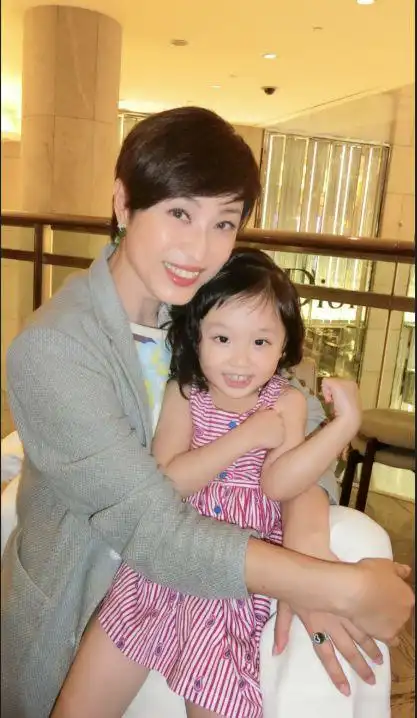 的腿上,不知道的还以为是母子俩,殊不知洪欣女儿长得更像爸爸多一点儿