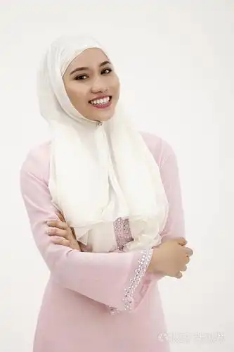 confidient 马来女人与粉红色的 baju kurung 看着相机