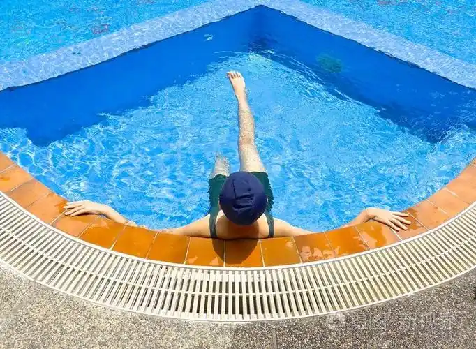 年轻女孩实践在游泳池里游泳