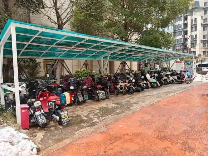 (小区电动车车棚)记者到来时看到,这两个户外车棚均已停满,很多电动车