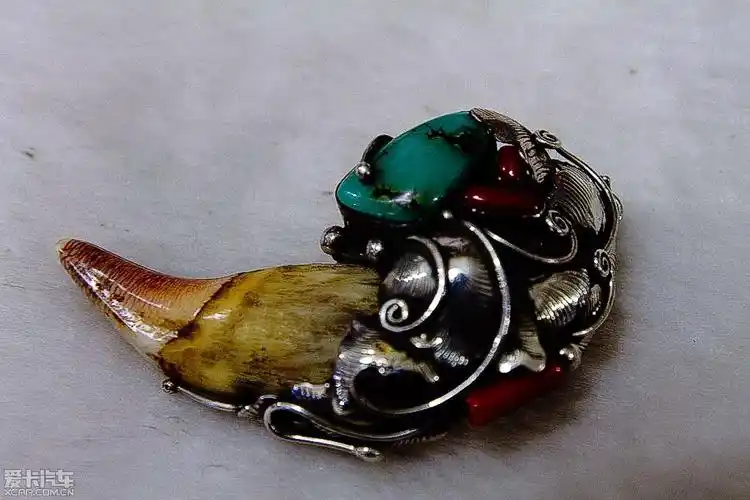 这里,一件纯银镶嵌熊牙的装饰品,造型美观引起了俺的兴趣.