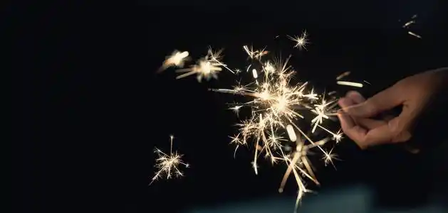 女人的手拿着闪闪发光的夜晚背景明亮的节日圣诞节或新年前夜照片