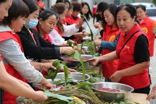 图为永乐路社区居民与周边村村民共同包粽子