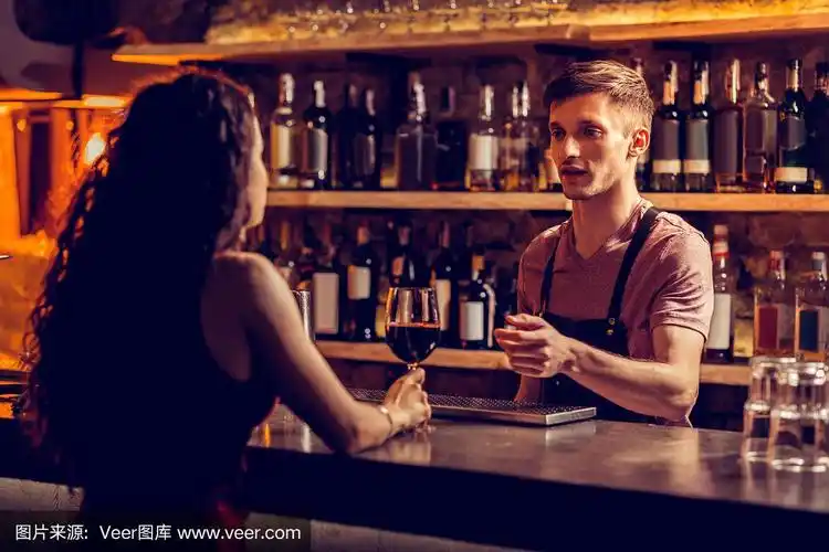 酒保和坐在吧台边喝酒的女人聊天