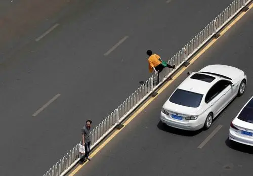 不愿多走100米,一小时20名市民涉险跨栏过马路