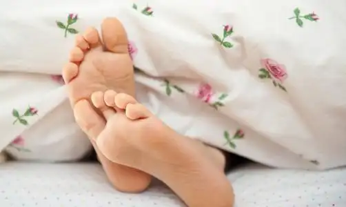 年轻的孩子光着脚在床上照片