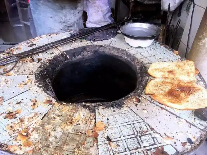 为了让做出来的饼皮足够酥脆,老板做烧饼依然坚持用老式的炉子