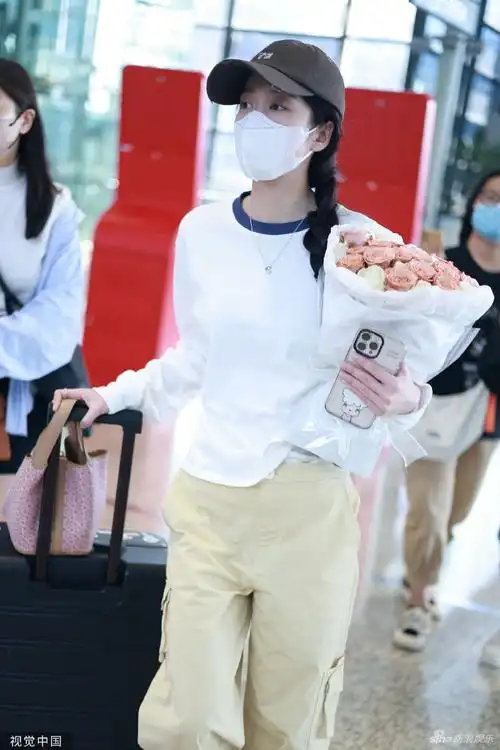 张雪迎手拿鲜花现身机场 绑单侧麻花辫温婉可人