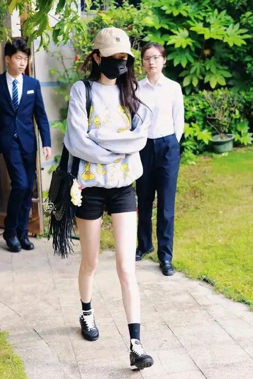 杨幂机场出发造型,灰色卫衣搭配黑色短裤棒球帽,大长腿不要太亮眼～好