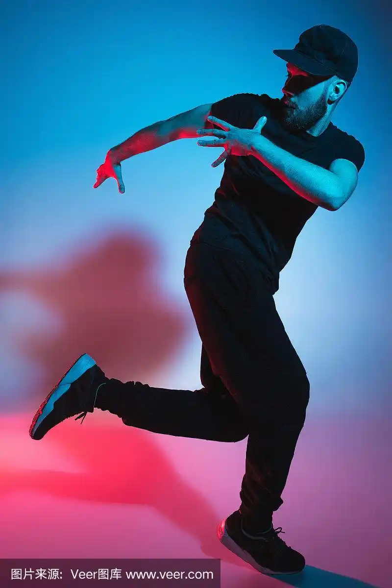 一个街舞男霹雳舞的剪影在多彩的背景上跳舞